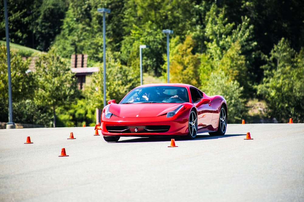 Coupé rojo sobre asfalto gris durante el día