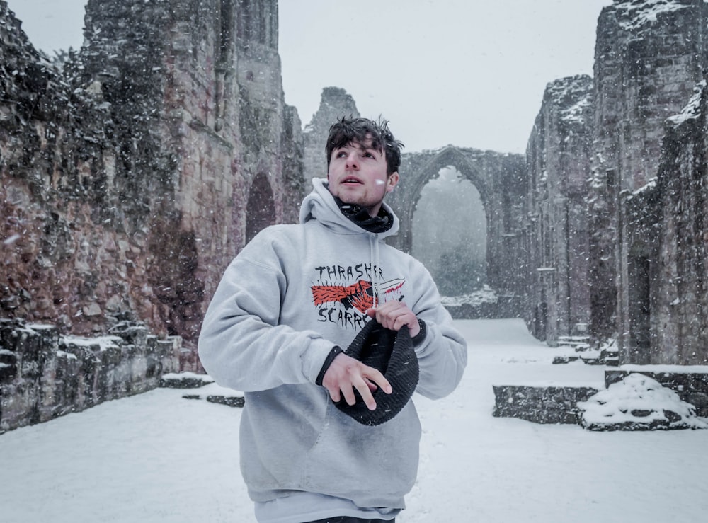 man in gray pullover hoodie in middle of city ruins