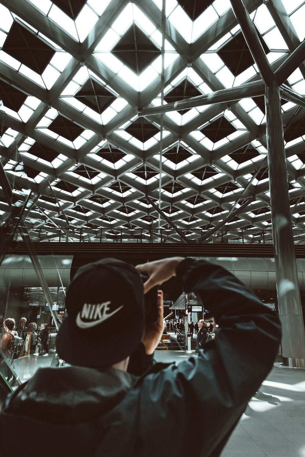 Mann mit schwarzer Nike-Kappe mit flacher Krempe und Kamera