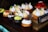 Image of an assortment of colorful pastries and cupcakes arranged on a rustic wooden table.