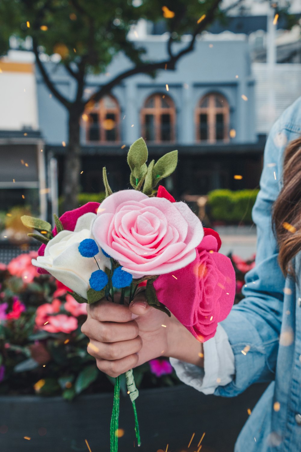 woman holding pink and white petaled faux flower