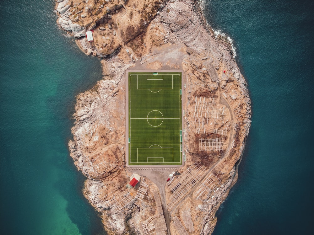 Fotografía aérea de un campo de fútbol cerca de un cuerpo de agua