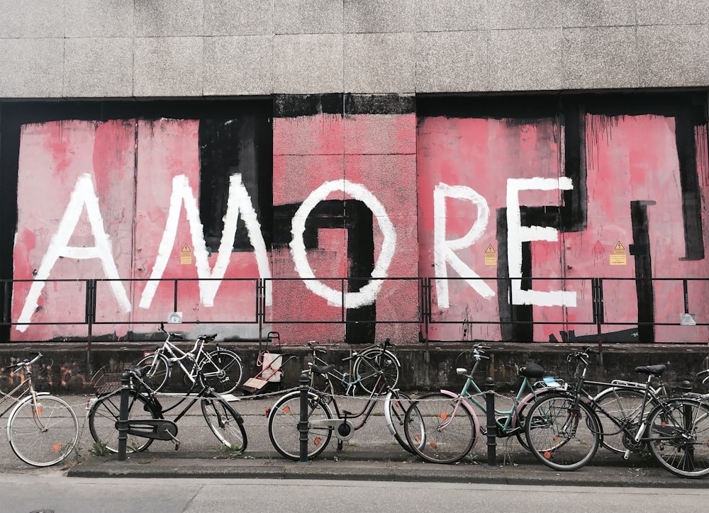 gray and black bicycles in front of Amore graffiti
