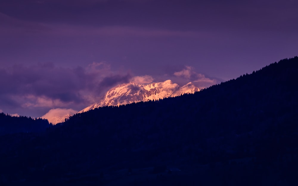 昼間の紫空の下の山のシルエット