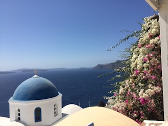 A charming whitewashed villa overlooking the Aegean Sea with vibrant bougainvillea.