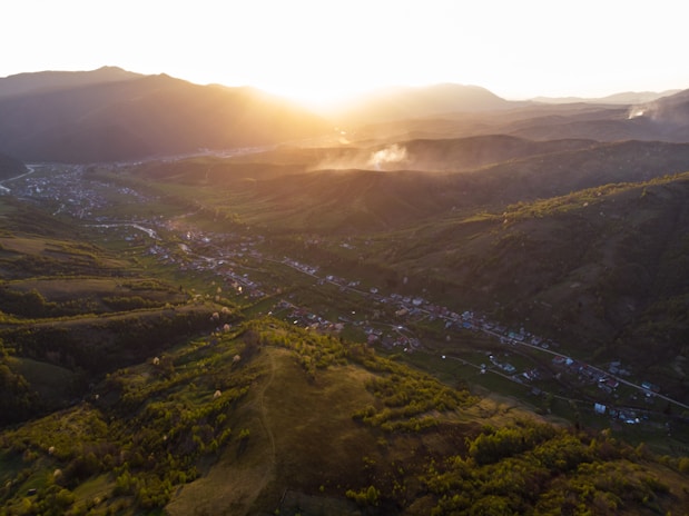 A sweeping aerial shot of the lush valleys and winding rivers in Rhondda Cynon Taf during golden hour.