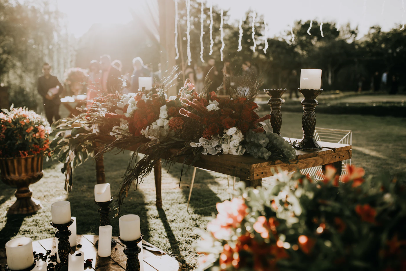 Fire pit ideas for cozy fall evening receptions — A fire pit area styled with blankets, pillows, and string lights for an autumn wedding.