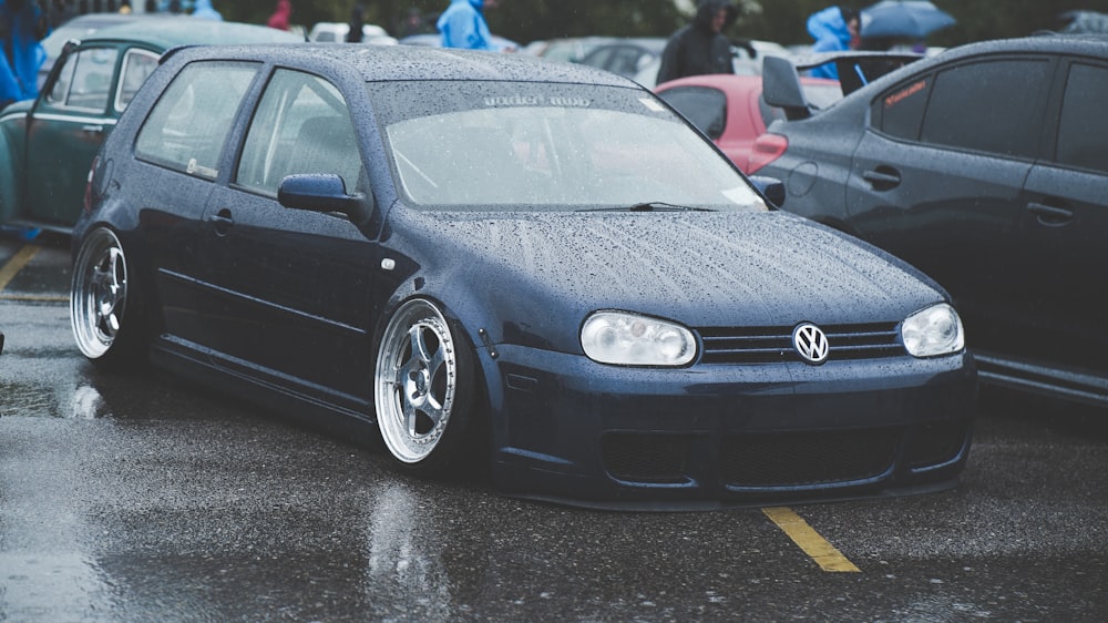 black Volkswagen vehicle parked near peoples and cars