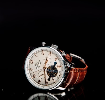 round silver-colored chronograph watch with brown leather strap