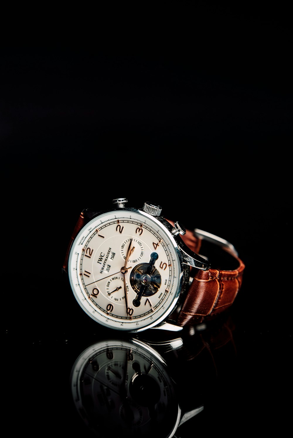 round silver-colored chronograph watch with brown leather strap