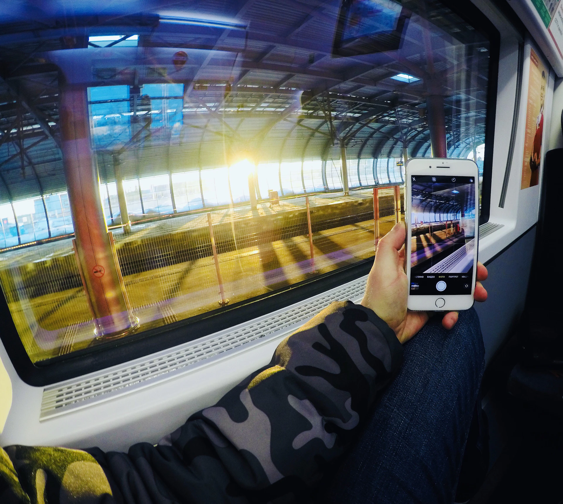 Traveler on Interlaken platform with smartphone, Alps background