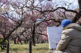 A candid shot of Maxwell Raines sketching in a sunlit park, surrounded by autumn leaves.