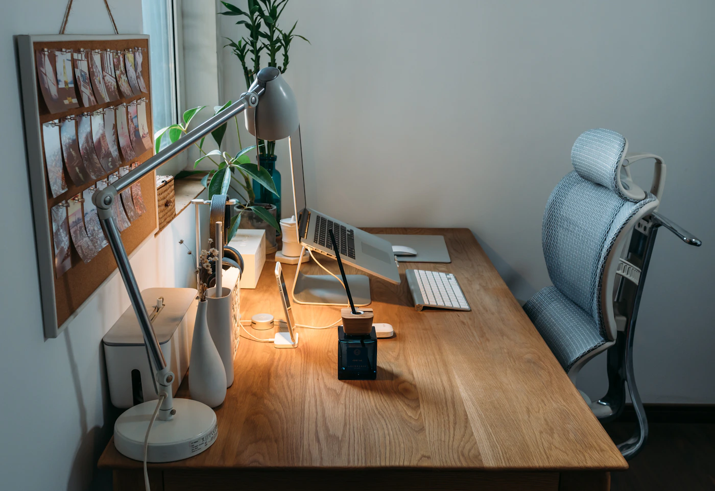 Cozy wooden workspace with a laptop, desk lamp, and plants