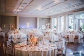 An elegant banquet hall set up with vibrant floral arrangements and ambient lighting.