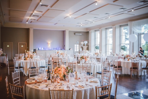 Elegant banquet hall with large windows overlooking the sea at sunset.