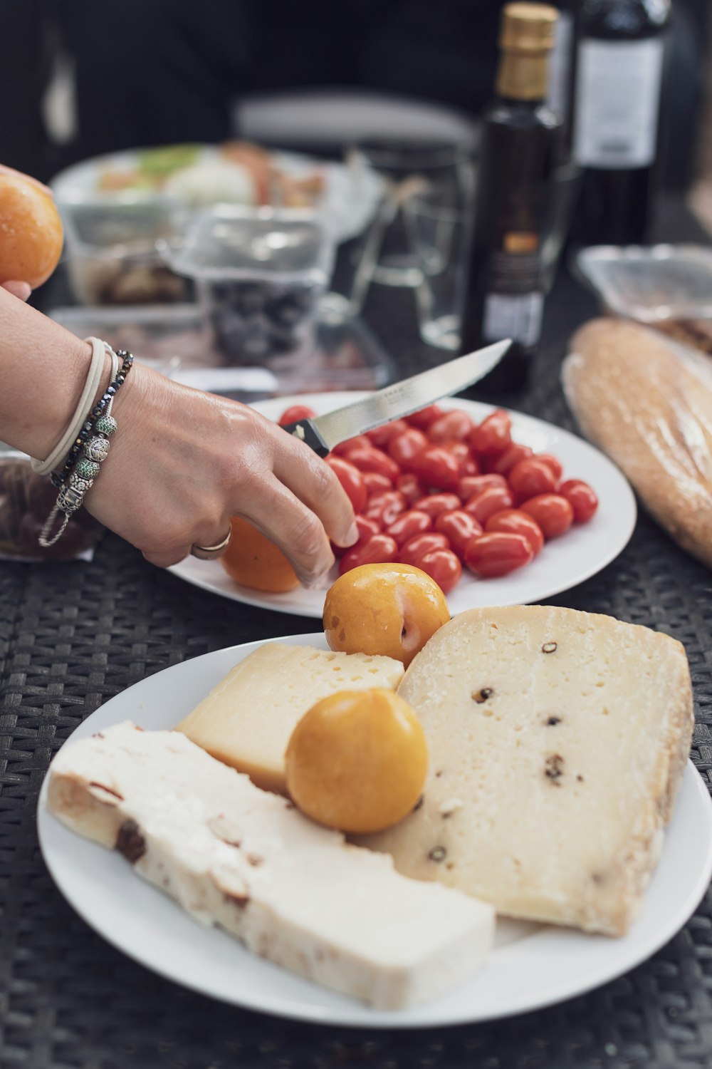 person holding knife near white ceramic plate