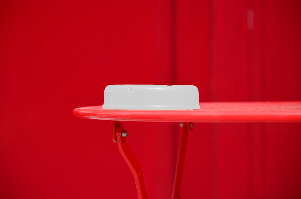 round white plastic container on red table