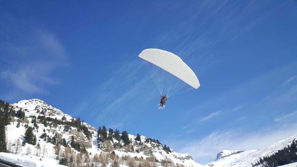 Persona que usa paracaídas cerca de la montaña