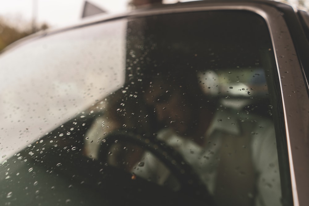 a man driving a car in the rain