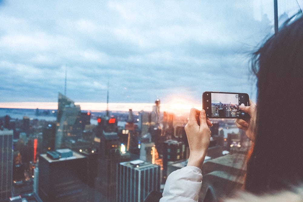 woman taking picture of high rise buildings