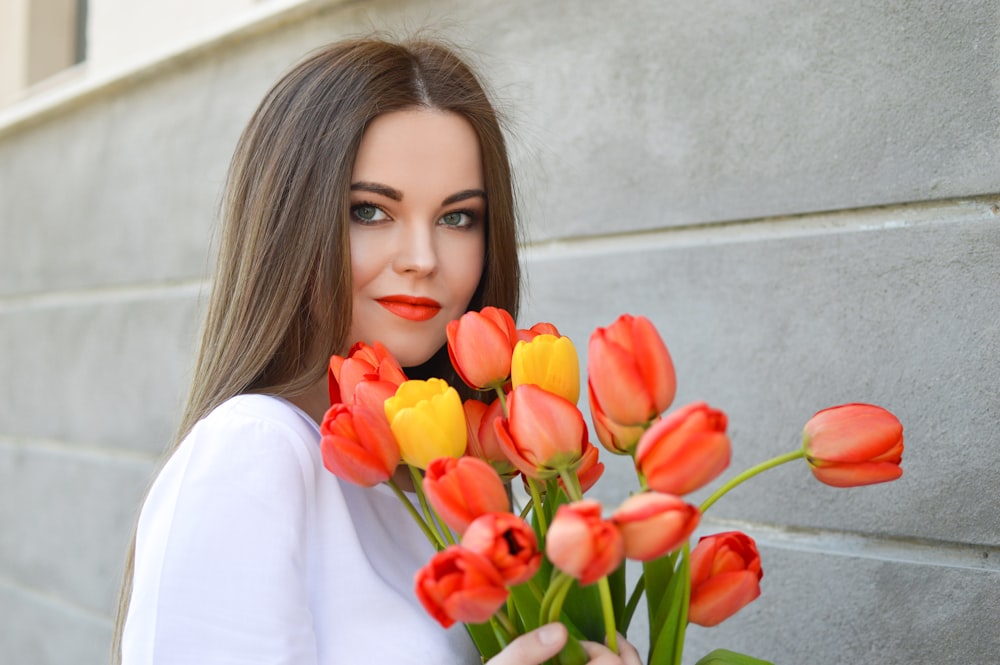 woman with bouquet of pink and yellow tulips