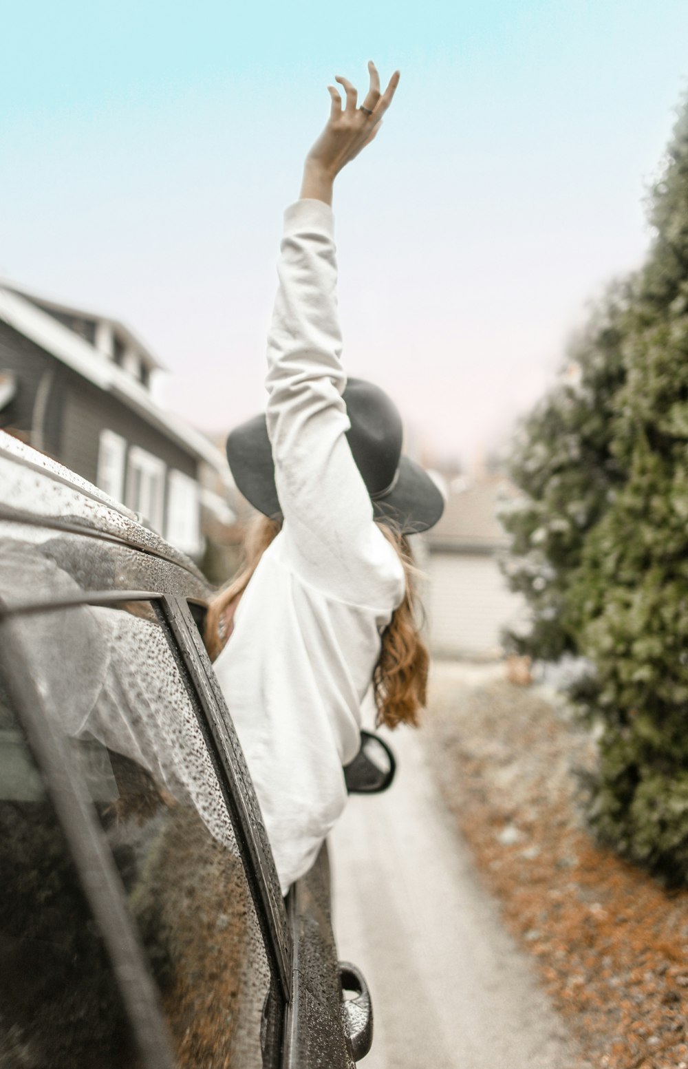 Mujer levantando la mano izquierda en la ventana del vehículo durante el día