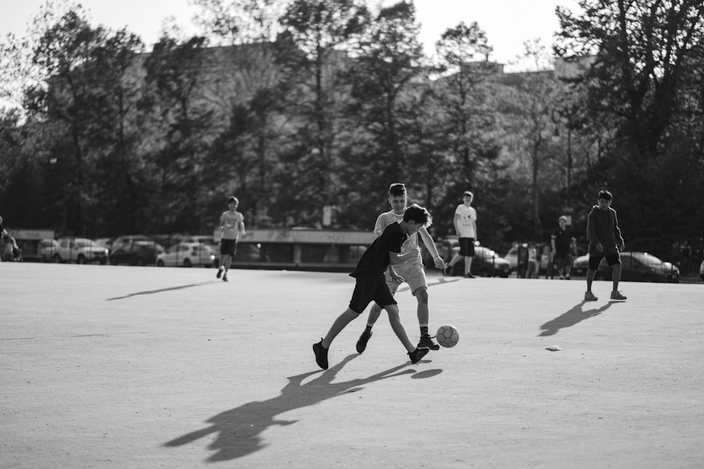Foto en escala de grises de un grupo de hombres jugando al fútbol en el campo