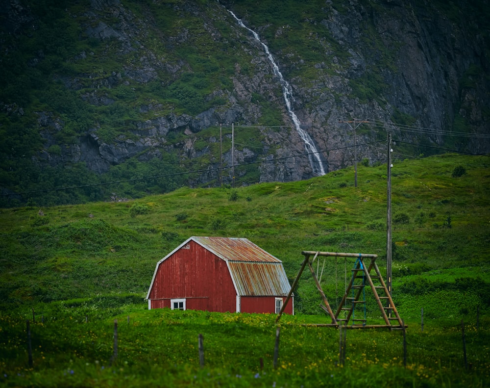 in distant photo of red barn on grass field