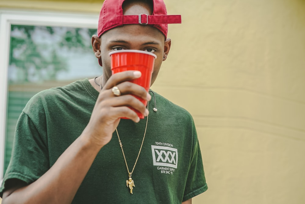 man holding red plastic cup