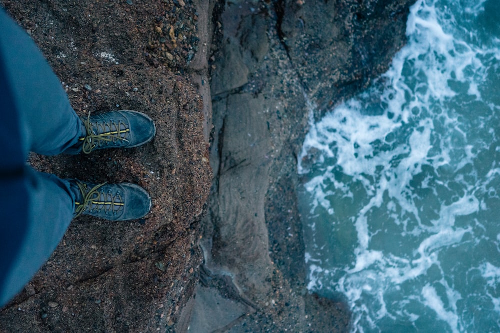 person standing on cliff far from water