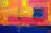 Close-up of vibrant abstract painting with bold strokes of blue, red, and gold.
