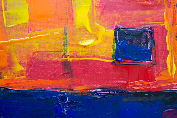 A vibrant abstract oil painting featuring bold strokes of red, gold, and navy blue.