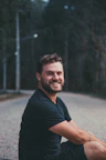 man sits on road