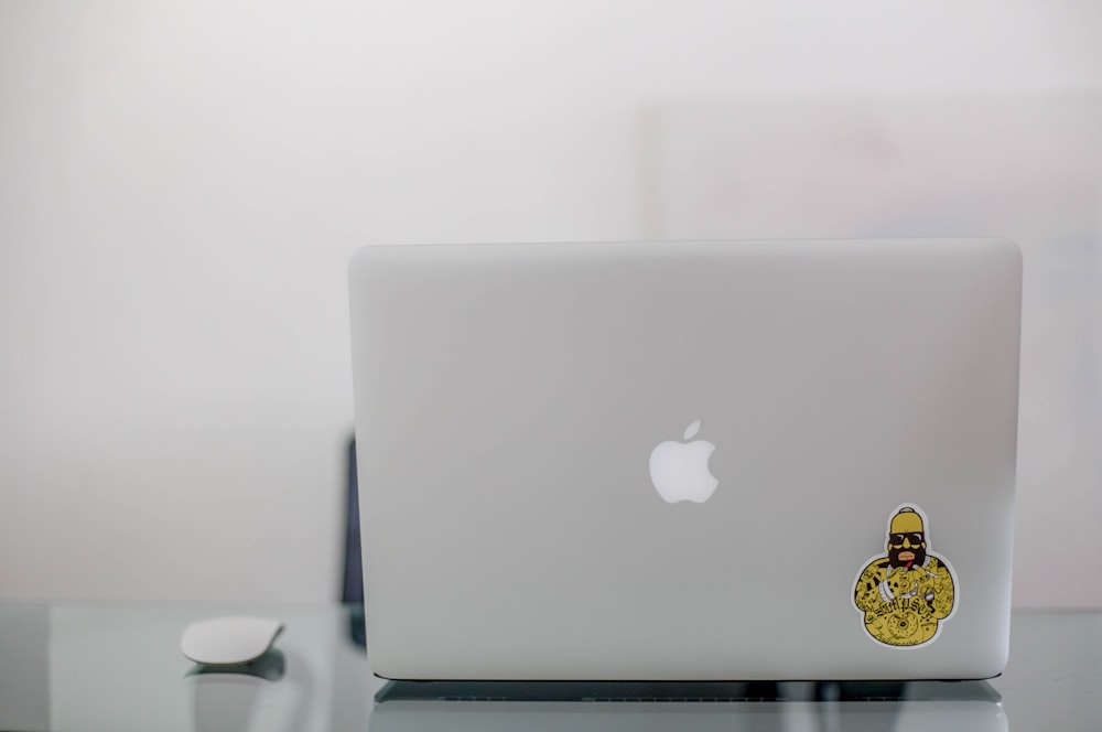 gray MacBook beside white magic mouse