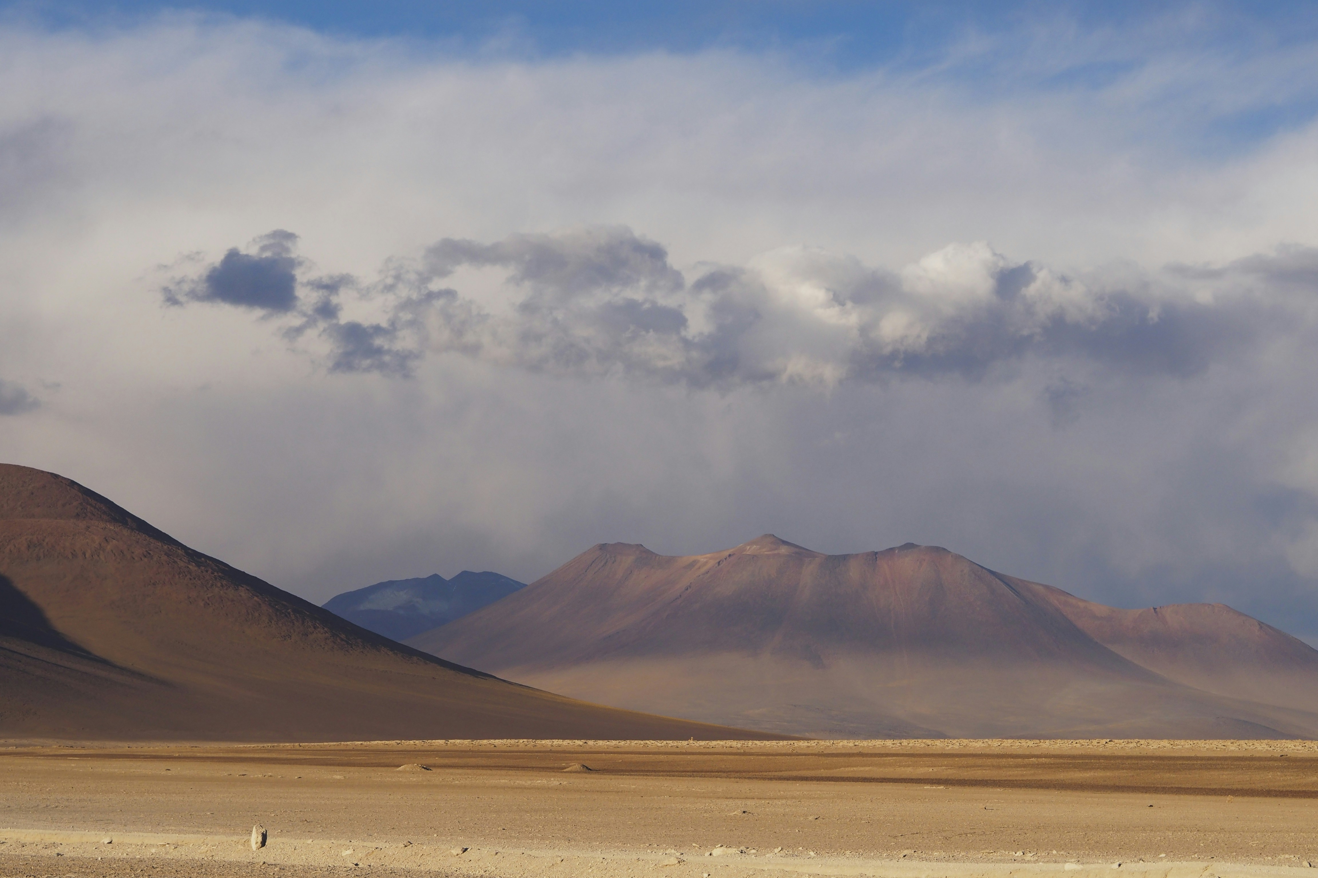 brown mountain beside desert during daytime, Taken near the border between Chile and Bolivia, during a tour that ended at the Uyuni Salt Flat.