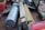 A close-up view of various hand tools and measuring devices, including a folded ruler with visible numerical markings and a large metallic tool with a cylindrical grip. The tools are arranged casually on a table, suggesting a workshop or garage setting.