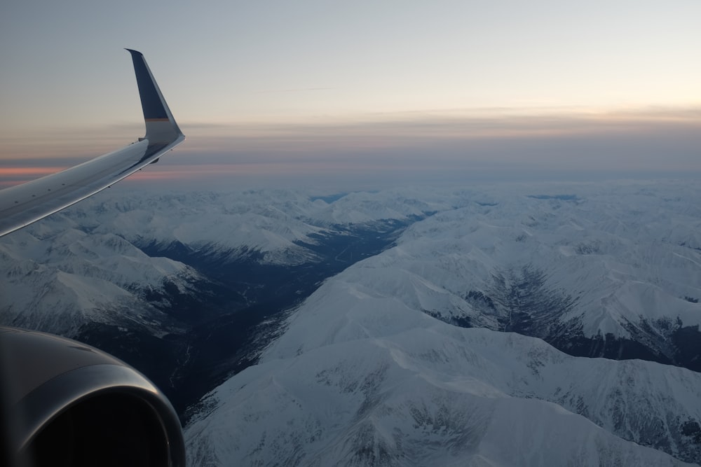 airplane flying above snowy mountains
