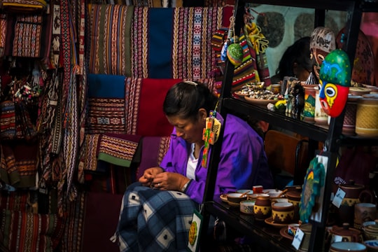 woman sitting near shelf in Cusco Peru