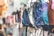A collection of colorful bikinis on display, hanging in a row. The designs include various patterns such as polka dots and abstract prints. The image has a soft focus on the left side, drawing attention to the vibrant swimwear.