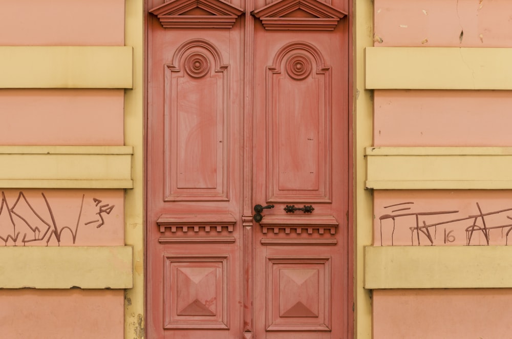 ピンクの壁にピンクの木製ドアの写真