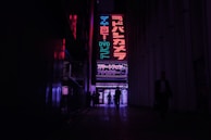 Neon-lit alleyway in Tokyo bustling with locals and vibrant signs at night.