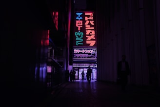 Neon-lit alleyway in Tokyo bustling with locals and vibrant signs at night.