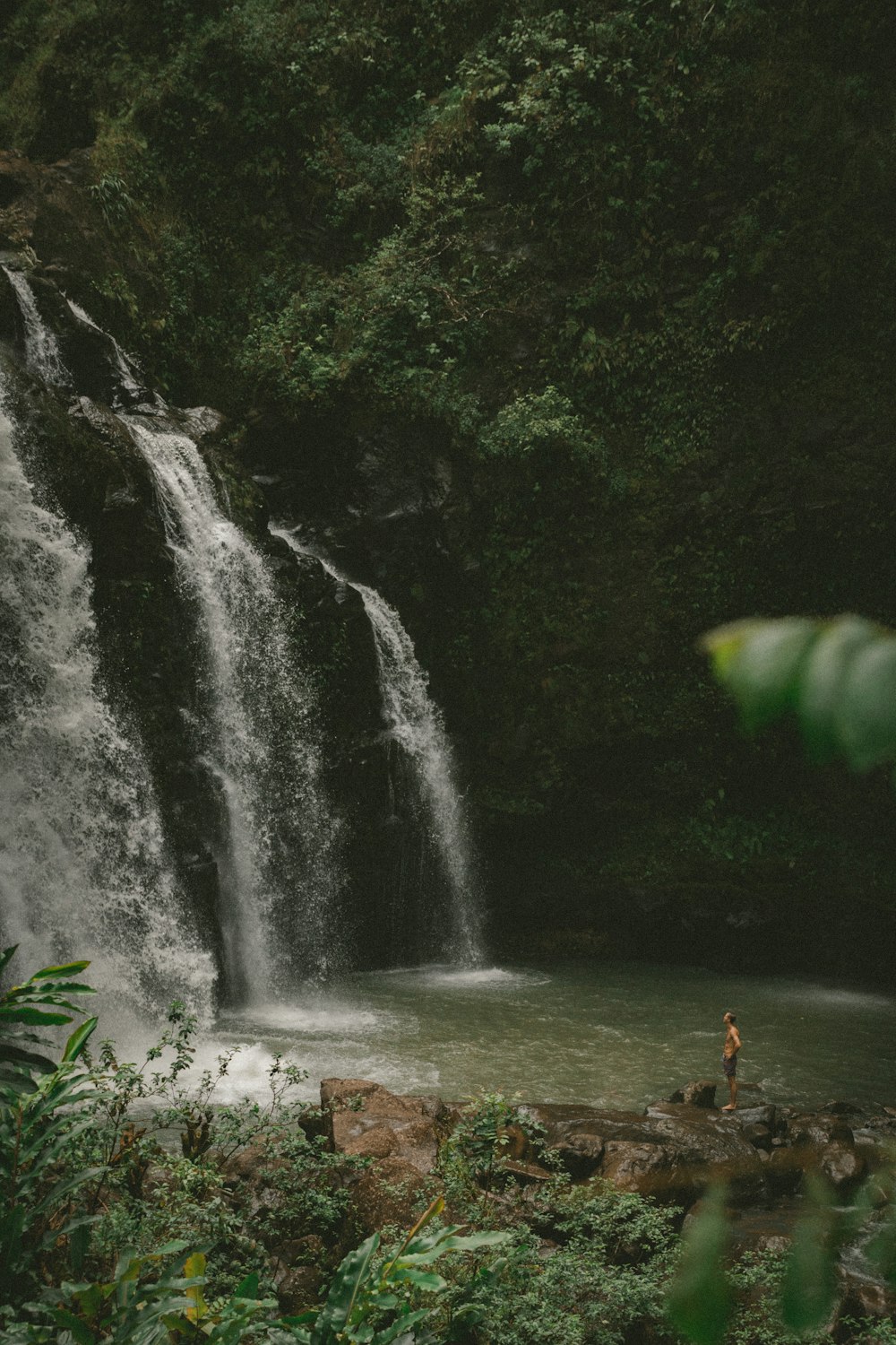 uomo in piedi sulla roccia che guarda le cascate