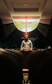 A warm, cinematic photo of Bruce speaking passionately at a church gathering with natural light.