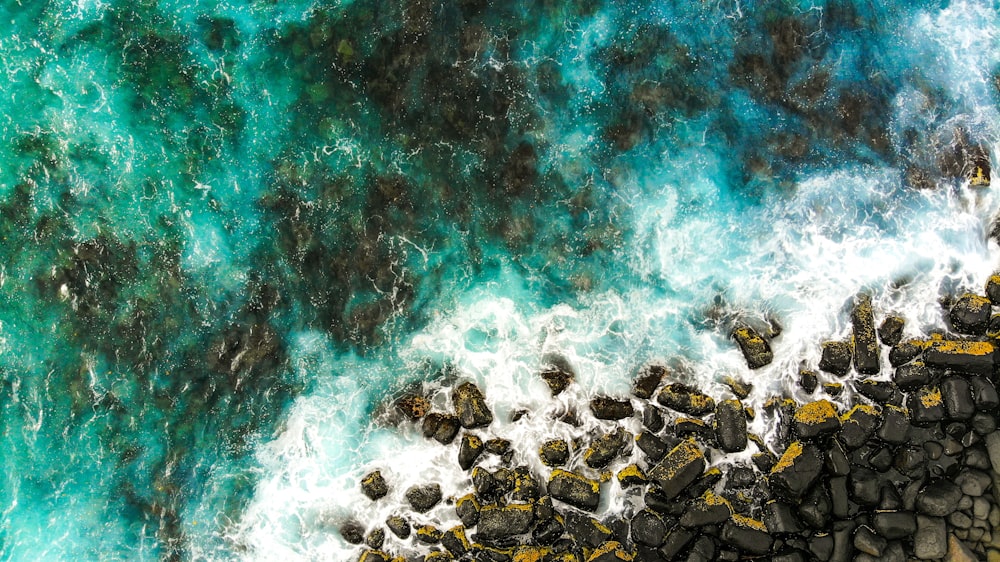 top view photo of brown stones and body of water