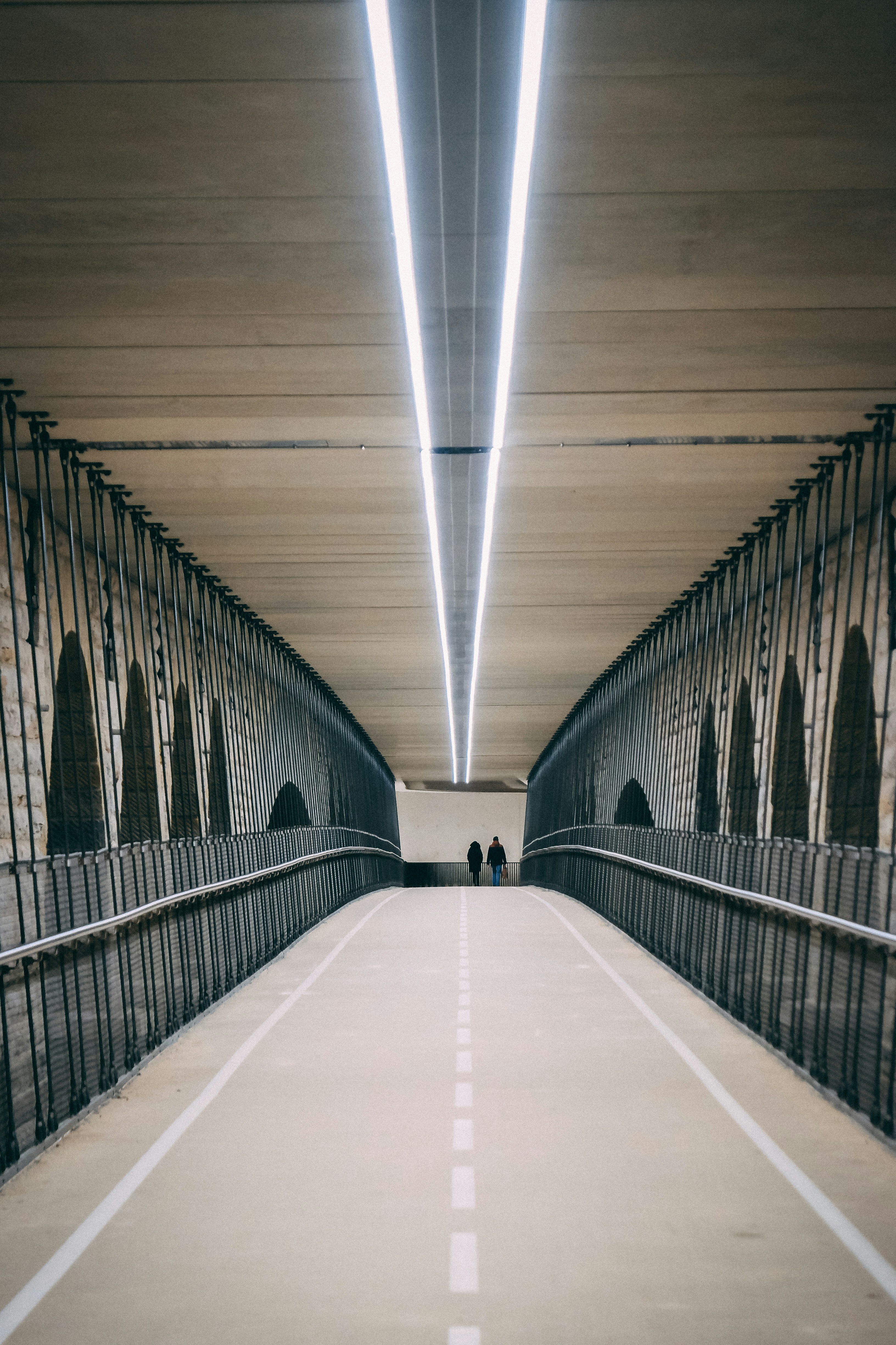 two person walking on bridge