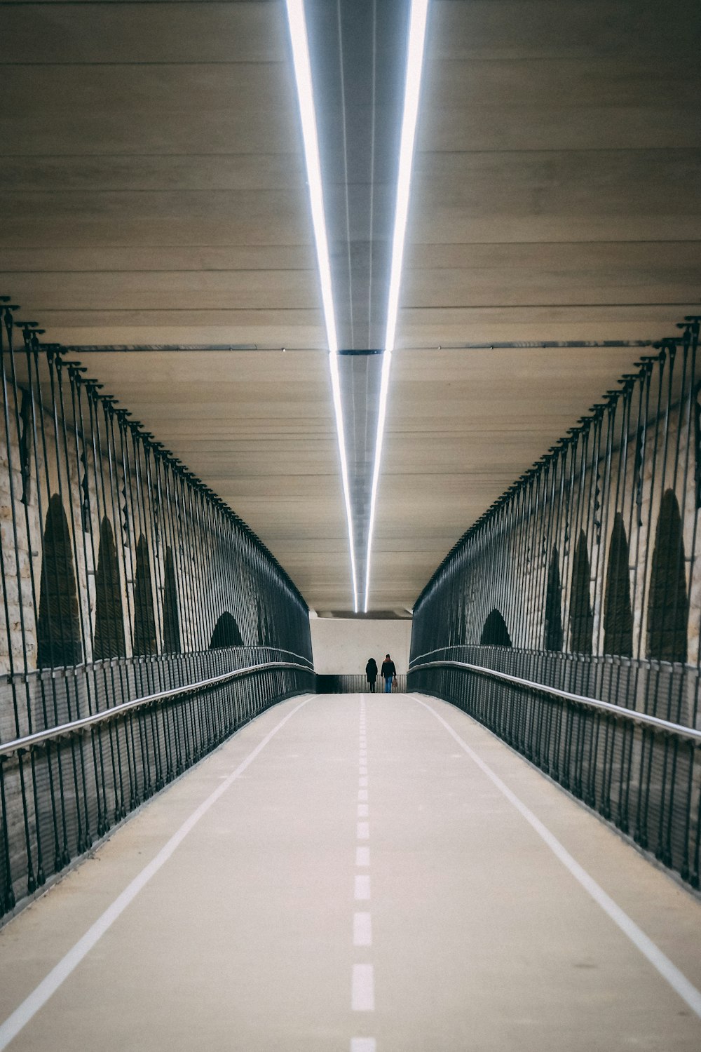 two person walking on bridge