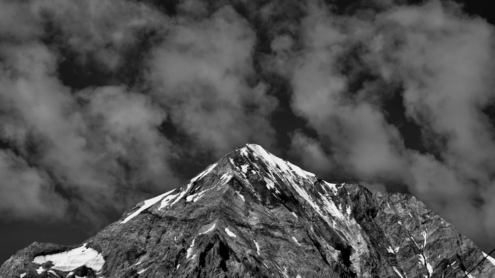 grayscale photo of mountain under cloudy sky