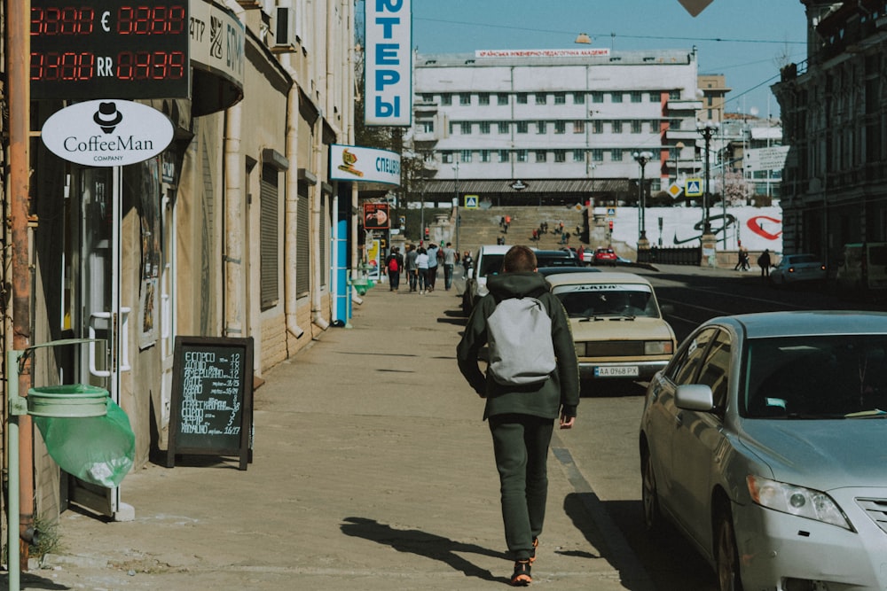 man walking along sidewalk during daytime