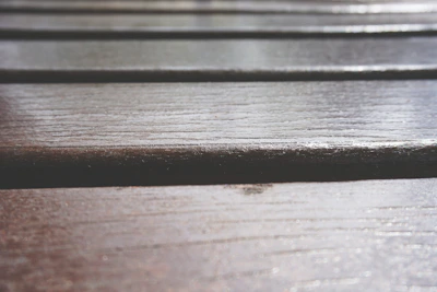 Close-up of elegant PVC flooring tiles with a natural wood grain finish in a sunlit modern living room.